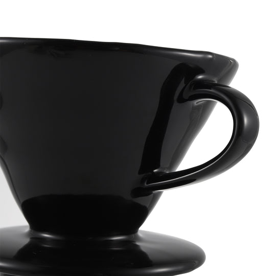 Close-up of the ergonomic side handle of the NERA Ceramic V-Shaped Pour Over Coffee Dripper, designed to provide a safe grip when the dripper is hot after brewing. The handle also allows for easy hanging for storage, drying, or display in your kitchen or coffee corner. VEVOK CHEF's thoughtful design ensures convenience and practicality.